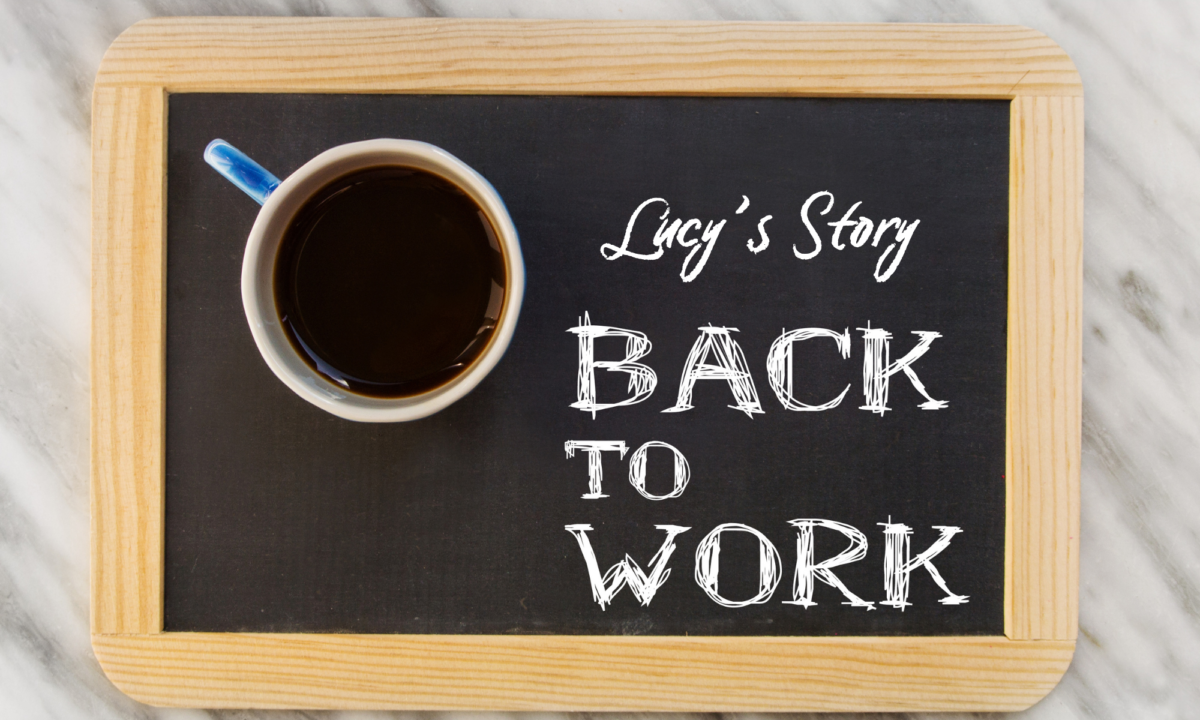 Above view of a blackboard with a coffee cup on it bearing the text "Lucy's Story. Back to Work"