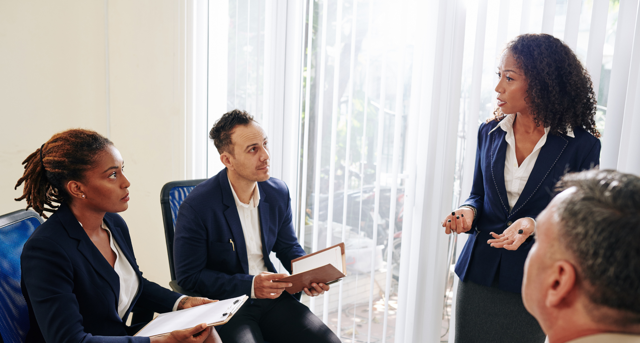 A group of business people getting together for a meeting in a conference room, discussing important matters with a woman who is is skilled in running effective meetings.