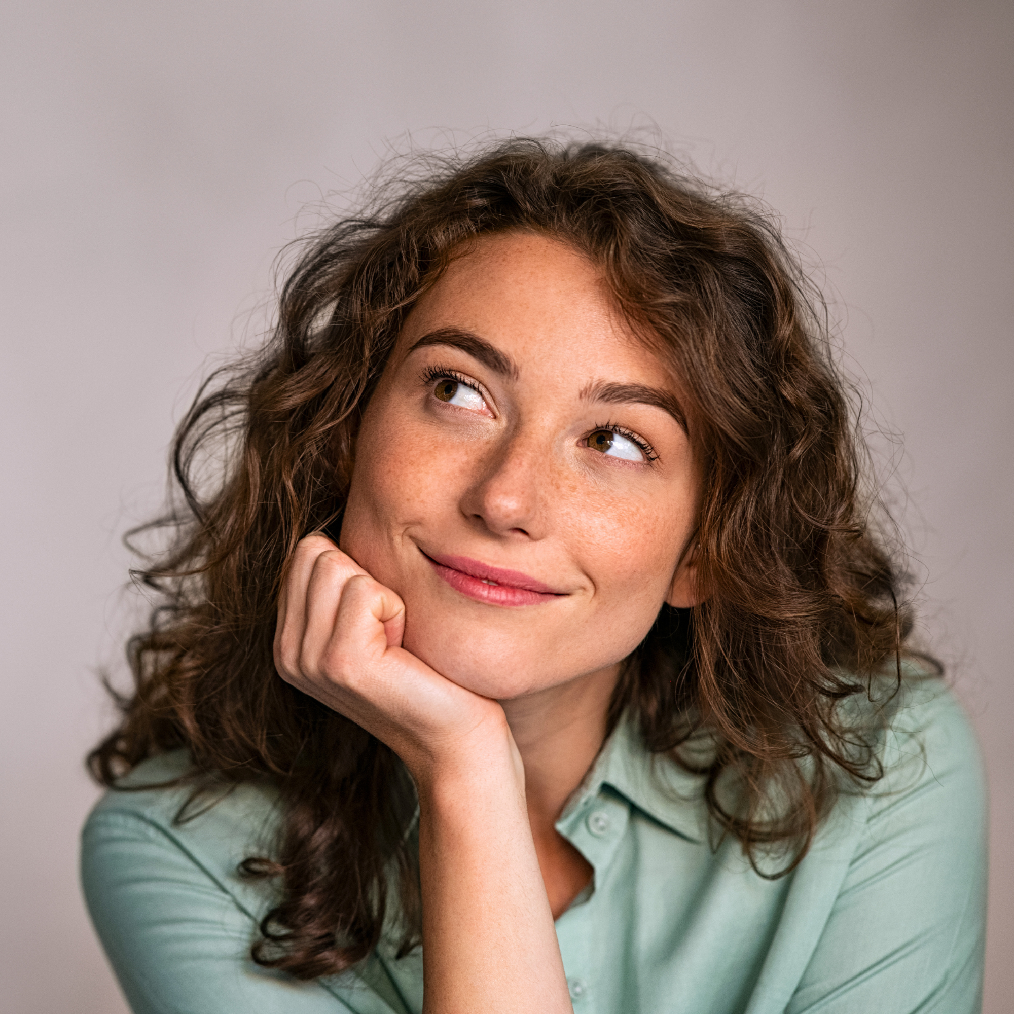 Head and shoulders of a woman smiling and thinking about her future.