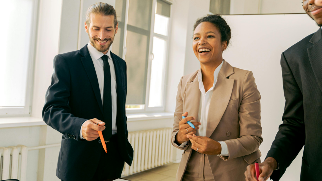 A smart man and a woman in an office, looking happy as they make the change from team member to manager.