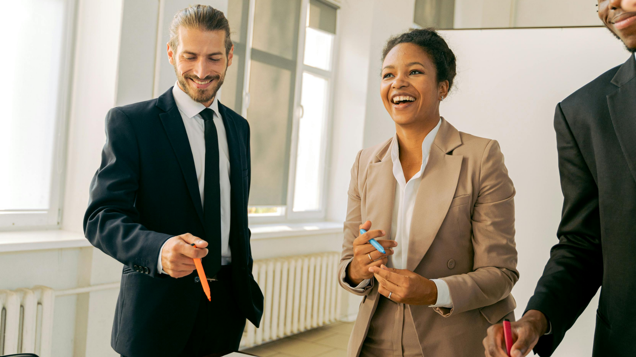 A smart man and a woman in an office, looking happy as they make the change from team member to manager.